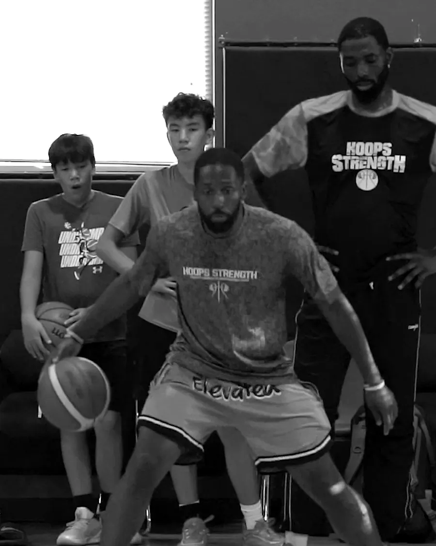 A trainer working the ball while players watch